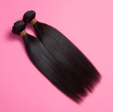 Black hair extensions on a pink background